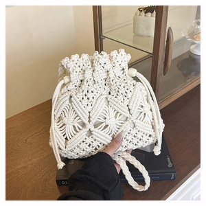 Detail of white handmade macrame bucket bag showing intricate geometric crochet patterns