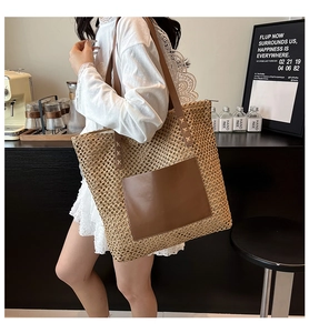 Detail of hand-woven straw tote with large brown leather pocket and long shoulder straps