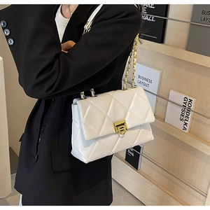 Détail du sac à chaîne en cuir matelassé blanc avec fermoir rotatif carré en métal doré