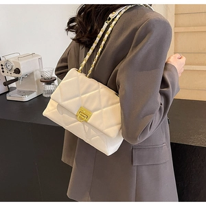 Détail du sac bandoulière blanc matelassé avec fermoir doré et bandoulière chaîne porté
