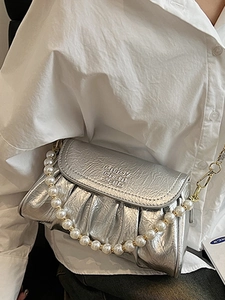 Sac nuage plissé argenté avec bandoulière en perles porté à l'épaule pour femme