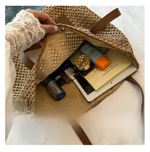 Detail showing the large interior capacity of a brown woven straw tote bag for beach vacations