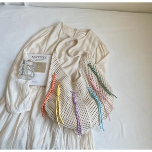 Detailed close-up of ivory crochet tote bag featuring vibrant multicolored woven tassels
