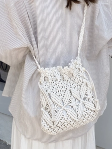 Minimalist woven macrame bucket bag with straw-like texture for summer beach fashion