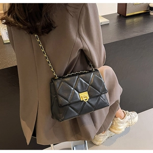 Sac noir matelassé chic avec boucle dorée présenté dans un décor de style de vie moderne