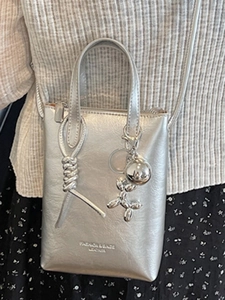 Borsa a tracolla argentata minimalista con nodo decorativo e ciondolo a cane palloncino