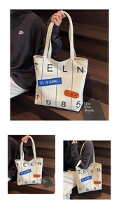 Detail view of large canvas tote bag with black stripes and TELN 1985 letter printing