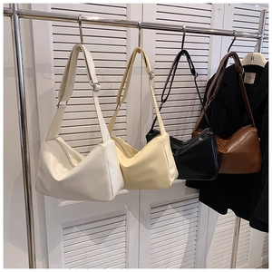 Detail view of four minimalist crossbody bags in white beige black and brown with wide straps
