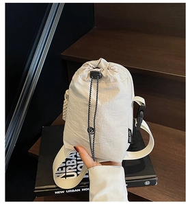 Détail du sac beige en nylon pour gourde avec cordon de serrage et étiquette de marque