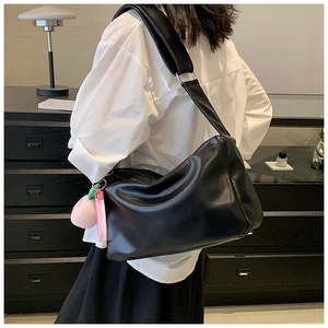 Close-up of black hobo shoulder bag with a peach charm and silver metal hardware