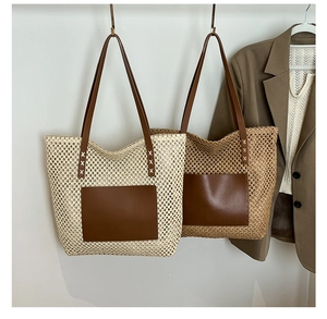 Detail of woven straw tote bag featuring leather shoulder straps and front pocket detail
