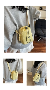 Vue détaillée du sac bandoulière jaune en nylon léger avec cordon de serrage et fermeture