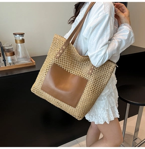 Detail of hand-woven straw tote bag with brown PU leather pocket and shoulder strap