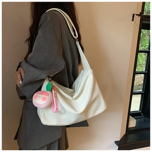 Close-up of beige tote bag with soft texture and stylish pink peach plush charm accessory