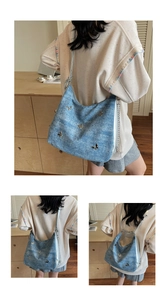 Détail du sac hobo en denim bleu avec papillons argentés en 3D et chaîne métallique style Y2K