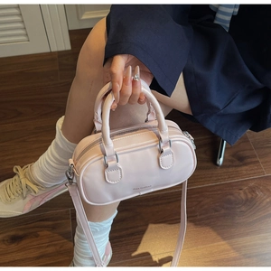 Detail of light pink mini Boston bag in glossy leather with detachable shoulder strap
