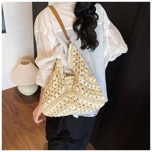 Detailed view of woven tote bag with hollow crochet pattern and brown leather strap