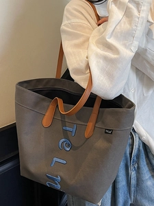 Large gray canvas tote bag with blue embroidery and brown leather handles for women