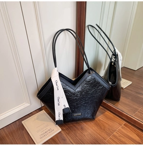 Detail of vintage black tote bag featuring V-shaped opening and decorative silk scarf