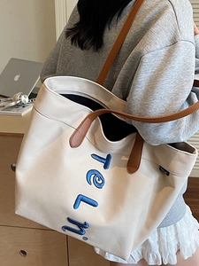 Large capacity off-white canvas tote bag with brown leather handles and blue embroidery