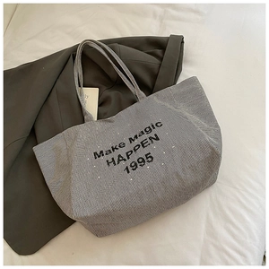 Detailed macro view of black and white striped canvas tote with Make Magic HAPPEN print