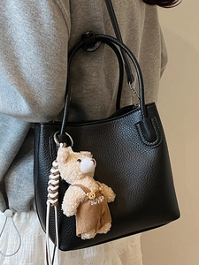 Fashionable black lychee grain bucket bag for women with a cute brown bear pendant