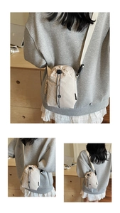 Gros plan d'un sac seau beige à cordon coulissant en nylon léger froissé