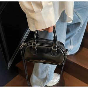 Detail of black glossy Boston mini bag with silver hardware and leather handles