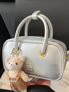 Silver metallic Boston handbag with golden hardware and a cute brown plush bear charm