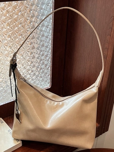 Minimalist beige glossy PU underarm bag with pleated texture and heart pendant charm