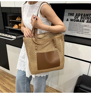 Close-up of woven straw tote bag with brown leather pocket detail and shoulder straps