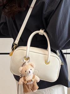 Creamy white faux leather tote bag with a cute brown plush bear charm and crossbody strap