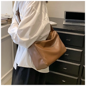 Detailed view of warm brown faux leather tote with wide strap for daily commute
