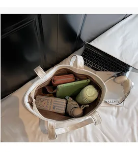 Vertical view of the spacious white tote bag interior with laptops and daily essentials