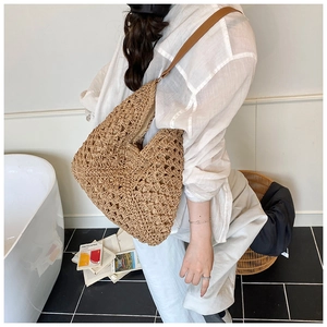 Close-up of woven tote bag with flower pattern texture and brown leather strap