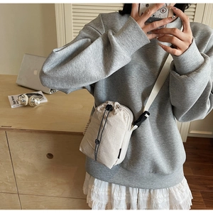 Détail du petit sac à bandoulière beige avec cordon de serrage et boucle ajustable