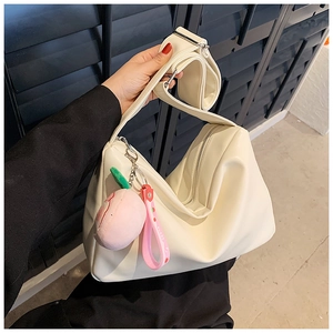 Detail of off-white PU leather tote bag with wide strap and sweet peach charm