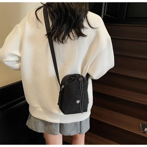 Vue détaillée du sac bandoulière noir en nylon avec cordon de serrage et logo mode
