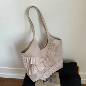 Detailansicht der cremefarbenen Tragetasche mit eleganten Rüschen und mattem Kunstleder