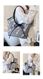 Detail view of a grey tweed tote bag with 3D floral appliques and a black bow accent