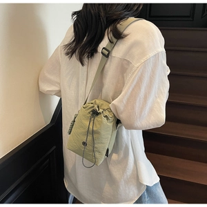 Détail du sac bandoulière en nylon vert haricot avec cordon et sangle réglable