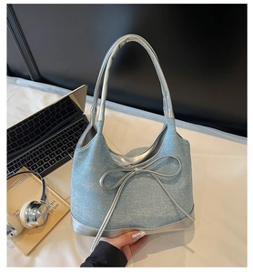 Dettaglio borsa in denim con fiocco in metallo argento e strass brillanti sulla borsa