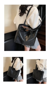 Detailed close-up of a large black tote bag with glossy finish and embossed digits