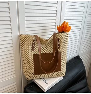 Detail of hand-stitched leather strap on white straw tote bag with front pocket