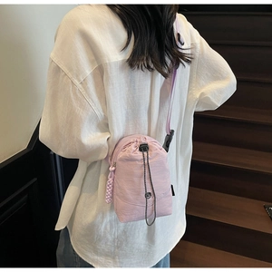 Détail d'un sac seau en nylon violet clair montrant la bandoulière réglable et douce