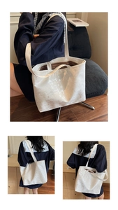 Detailed macro view of large cream tote bag with chic digital print and striped lining