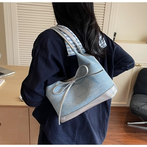 Dettaglio della borsa a spalla in denim azzurro con fiocco argento e strass lucidi