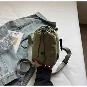 Vue détaillée du sac seau en nylon vert olive avec bandoulière grise réglable