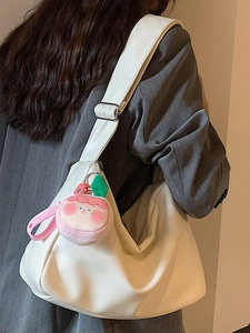 Minimalist white crescent shoulder bag with wide strap and pink peach plush pendant