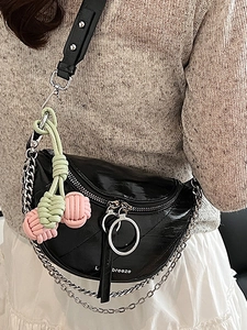 Fashionable black patent leather crescent crossbody bag with silver chain and weave charm